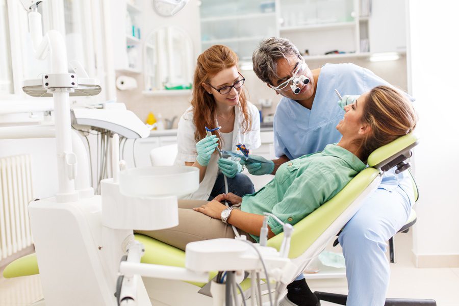 Group Dental Insurance - Dentist and Dental Assistant Performing a Cleaning