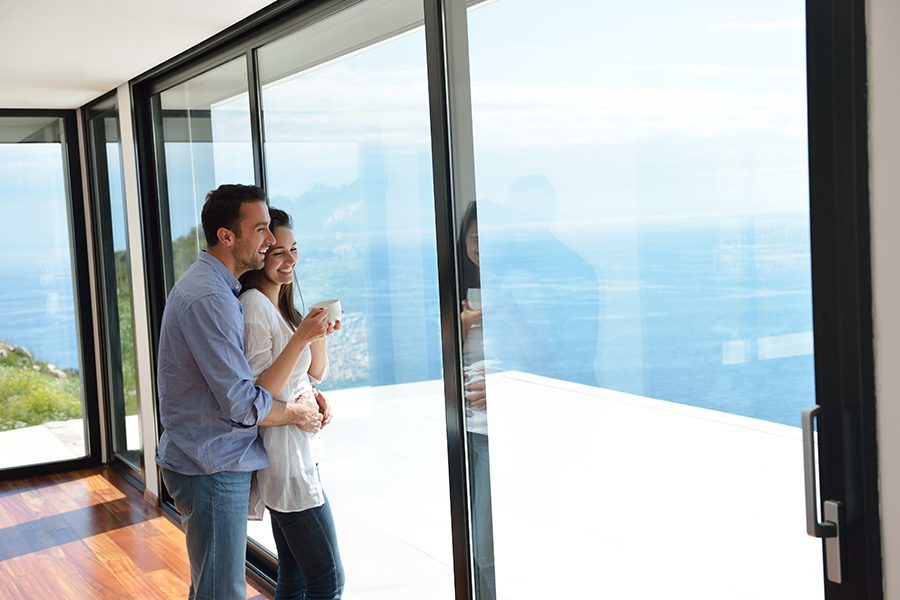 Client Center - Smiling Couple Looking at the Ocean From Their Modern Home