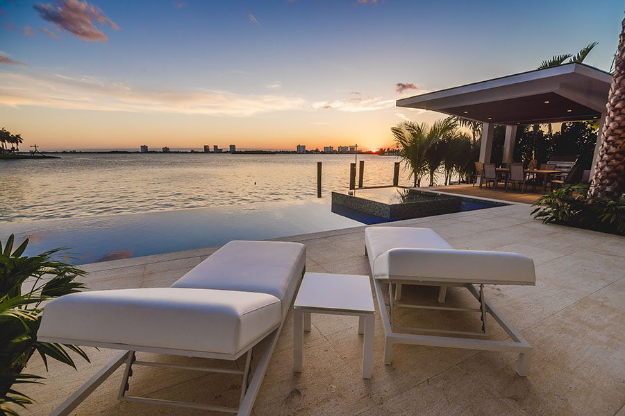Home Abroad Insurance - View of Lounging Chairs Near the Bay at Sunset
